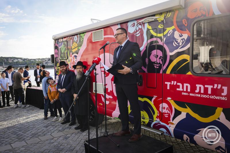 Budapest, 2024. szeptember 30. Fürjes Zoltán, a Miniszterelnökség egyházi és nemzetiségi kapcsolatokért felelős helyettes államtitkára beszédet mond az első magyarországi micvamobil, azaz kerekeken guruló zsinagóga átadásán a Cipők a Duna-parton emlékműnél 2024. szeptember 30-án. Mellette Oberlander Báruch rabbi, a Budapesti Ortodox Rabbinátus és a Chabad-Lubavics irányzat magyarországi vezetője (jobb2) és Köves Slomó, az Egységes Magyarországi Izraelita Hitközség (EMIH) - Magyar Zsidó Szövetség vezető rabbija (jobb3). A jármű naponta egy-két órán keresztül a Cipők a Duna-parton emlékműnél lesz megtekinthető, a fennmaradó időben pedig Budapest utcáit járja majd, hogy a város különböző pontjain érjen el zsidókat és segítse őket egy-egy micva, vagyis tórai parancsolat, jócselekedet végrehajtásában. Az eseményen a magyarországi holokauszt 80. évfordulójáról, illetve az Izraelt tavaly október 7-én ért terrortámadásról tartottak megemlékezést. MTI/Hegedüs Róbert
